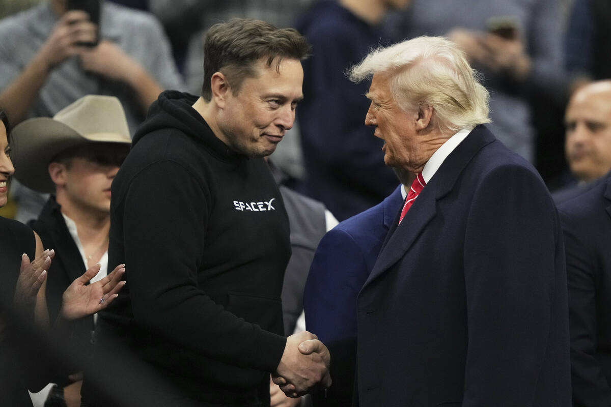 Elon Musk, left, shakes hands with President Donald Trump at the finals for the NCAA wrestling ...