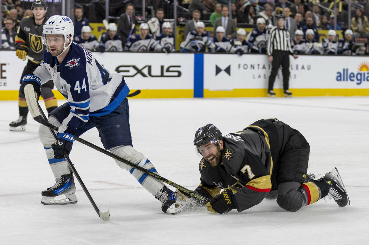 Golden Knights defenseman Alex Pietrangelo (7) goes down as Winnipeg Jets defenseman Josh Morri ...