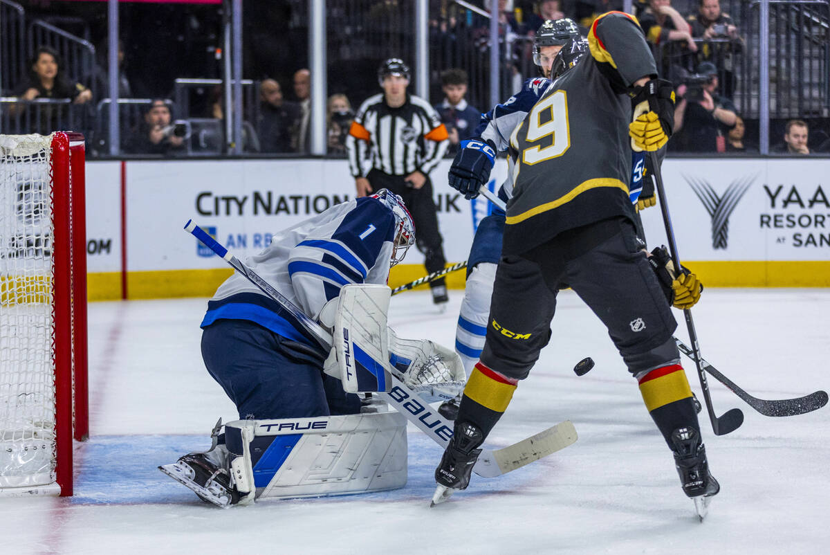Winnipeg Jets goaltender Eric Comrie (1) attempts another shot block from Golden Knights right ...