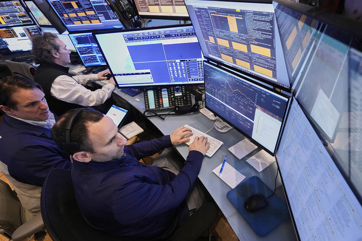Traders work in their booth on the floor of the New York Stock Exchange, Friday, April 4, 2025. ...