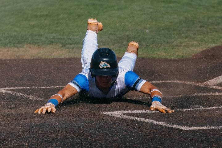 Basic’s Dallon Cegavske (24) dives into home plate to score a run for the Wolves during the b ...