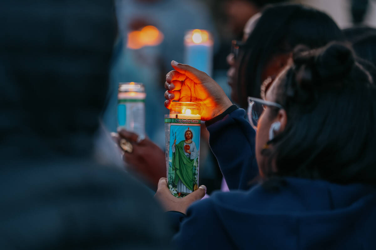 Loved ones hold candles during a vigil for three-year-old Journei Ross on Friday, April 4, 2025 ...