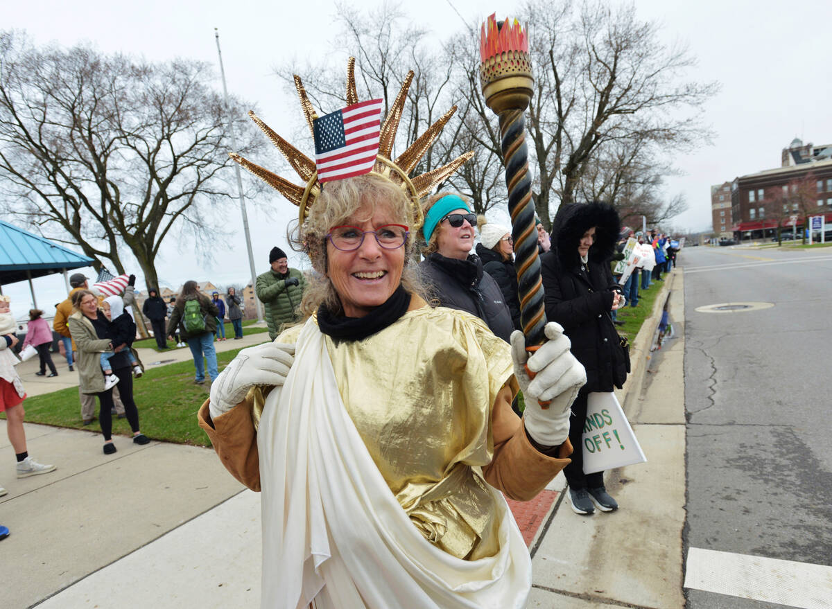 Barbara Starke joins hundreds of people gathered in downtown St. Joseph, Mich., Saturday, April ...