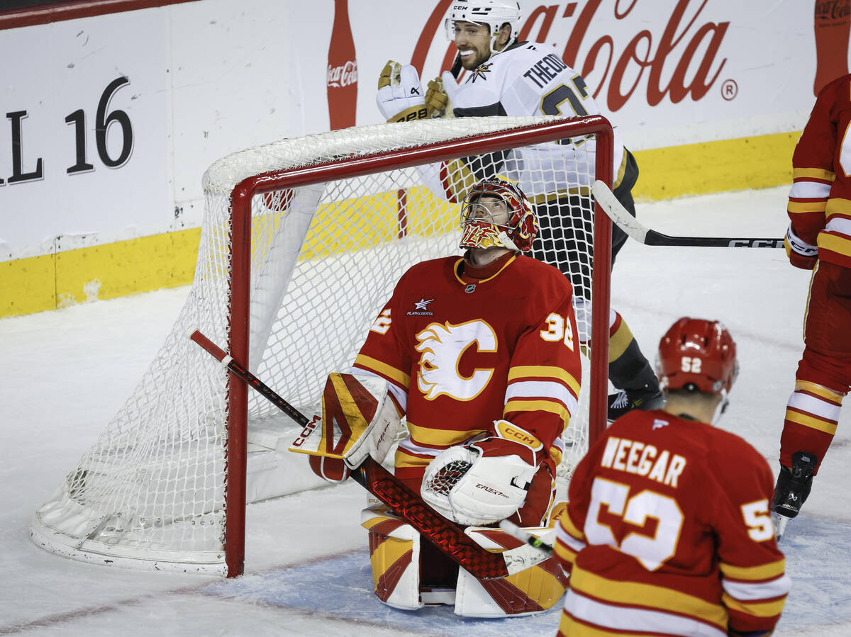 Vegas Golden Knights' Shea Theodore, top, celebrates his team's winning goal as Calgary Flames ...