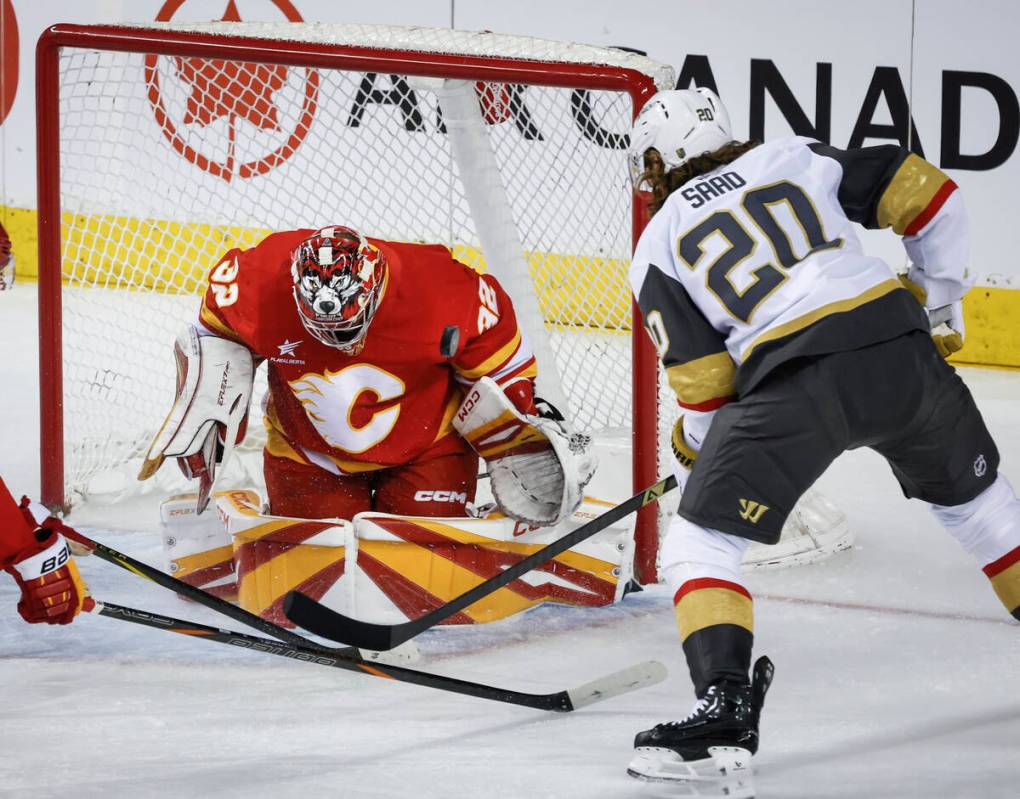 Vegas Golden Knights' Brandon Saad, right, has his shot blocked by Calgary Flames' goalie Dusti ...