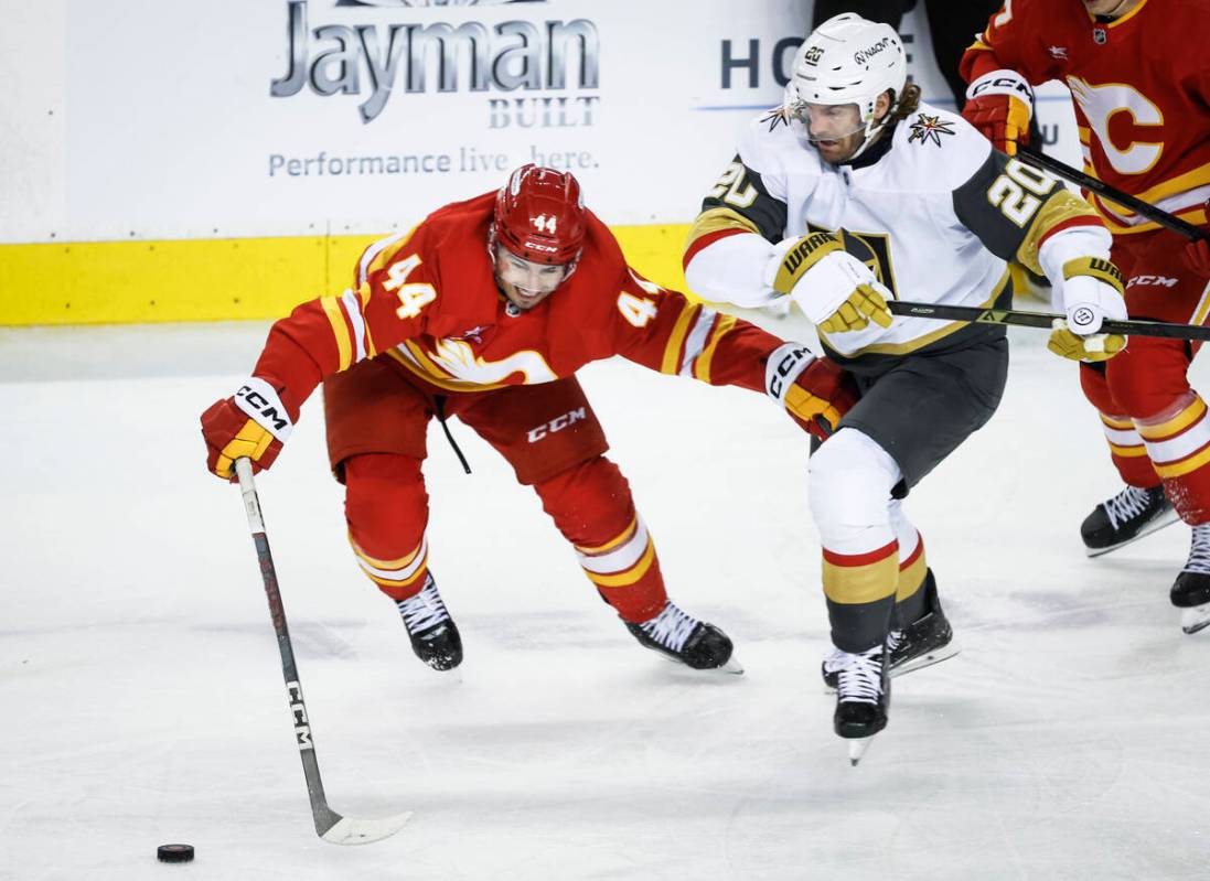 Vegas Golden Knights' Brandon Saad, right, and Calgary Flames' Joel Hanley race for the puck du ...