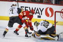 Vegas Golden Knights goalie Akira Schmid, right, grabs the puck as Calgary Flames' Martin Pospi ...