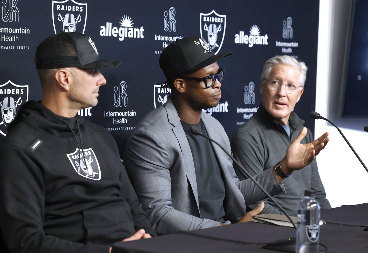 Raiders general manager John Spytek, left, and head coach Pete Carroll listen as Geno Smith, ce ...
