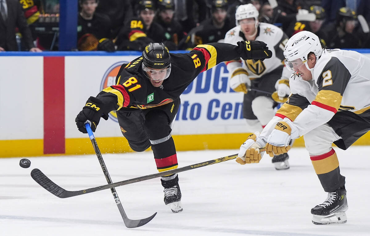 Vancouver Canucks' Dakota Joshua (81) and Vegas Golden Knights' Zach Whitecloud (2) vie for the ...