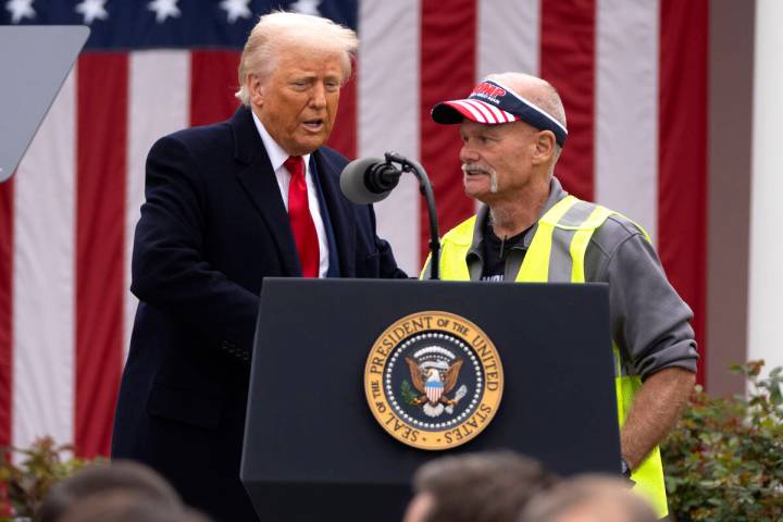 Retired autoworker Brian Pannebecker shakes hands with President Donald Trump during an event t ...