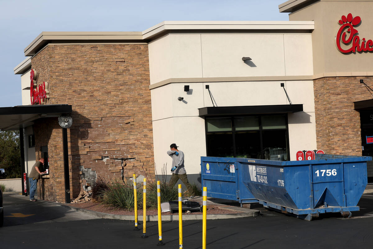 Workers make preparations to repair a Chick-fil-A after a car struck the business in Henderson ...