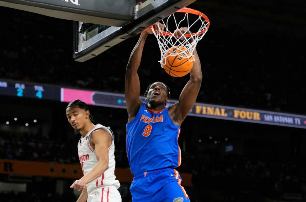 Florida's Rueben Chinyelu (9) dunks the ball as Houston's Milos Uzan defends during the first h ...