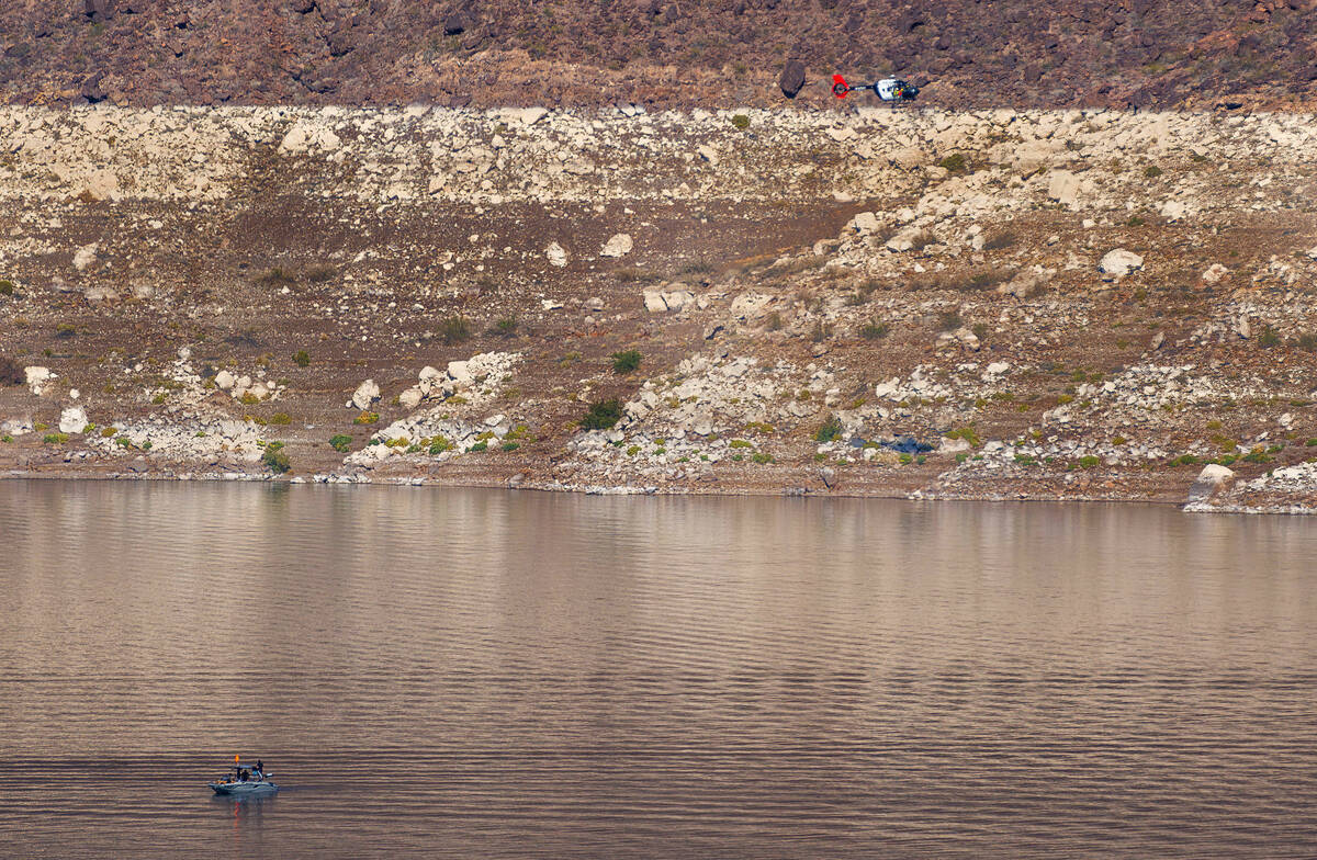 A rescue helicopter searches about the far shoreline adjacent to the Las Vegas Boat Harbor with ...