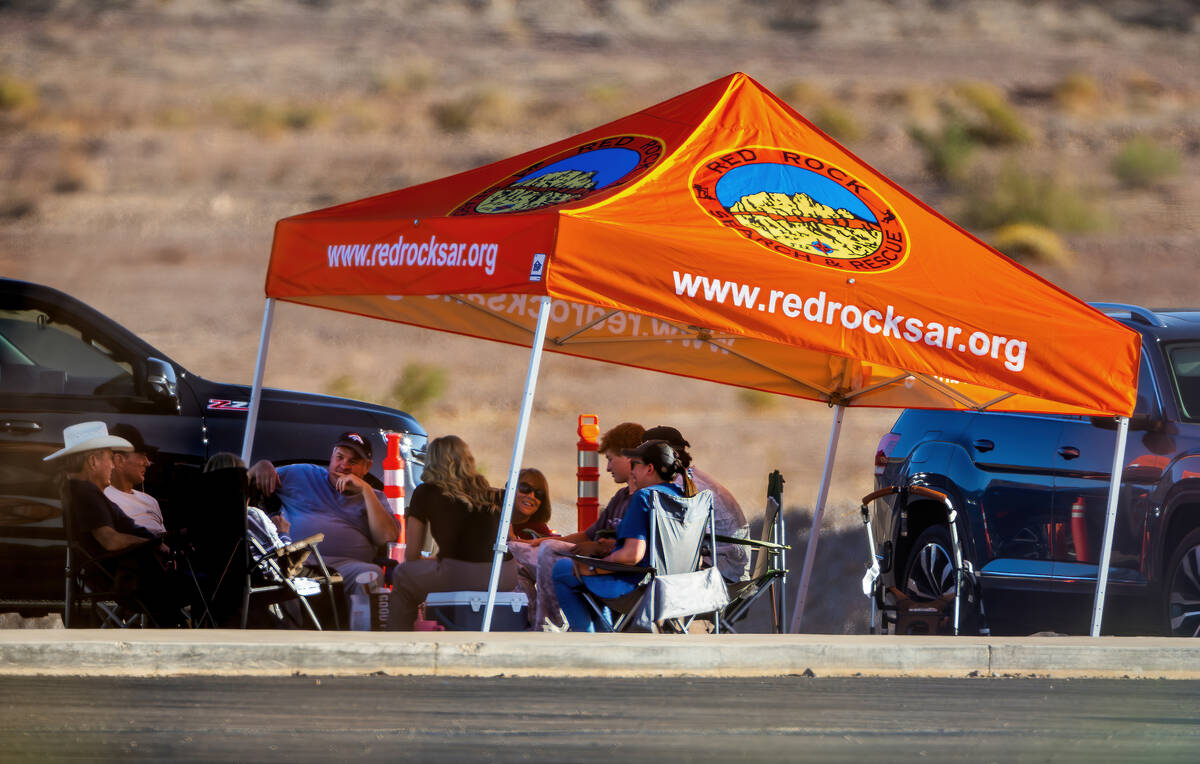 Family members and volunteers stay cool under a tent from Red Rock Search & Rescue near the ...