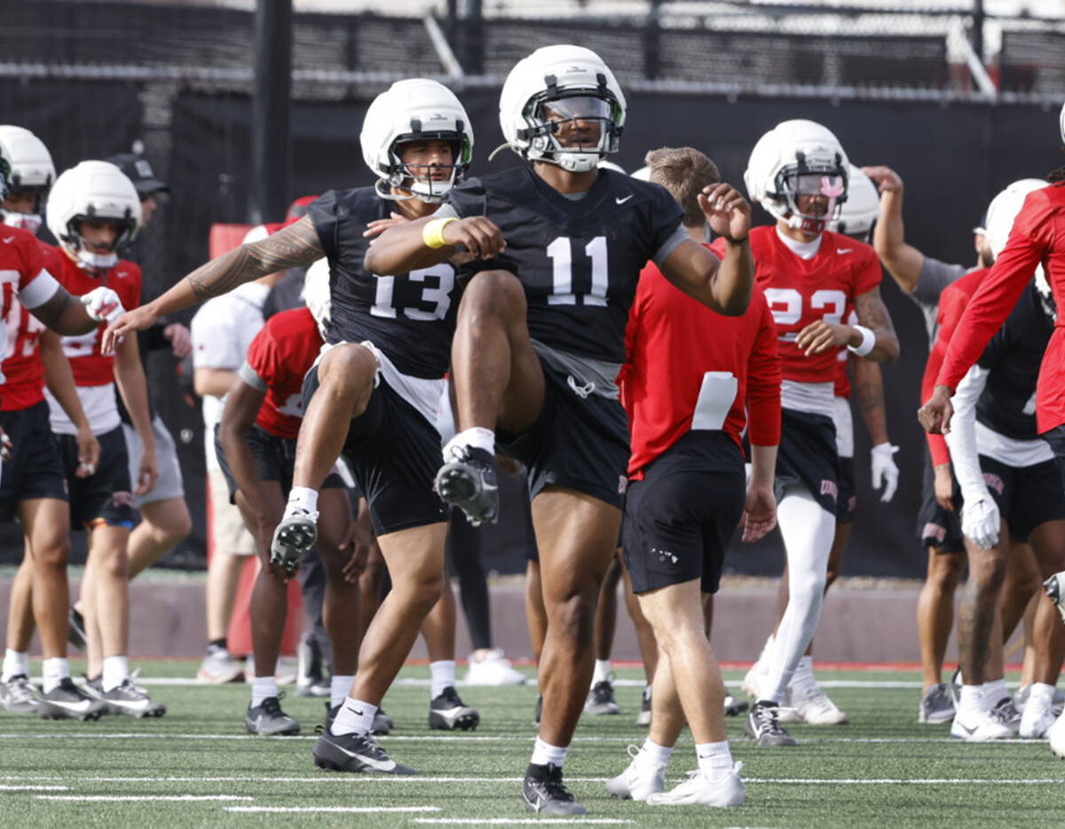 UNLV quarterbacks Cameron Friel (13) and Alex Orji (11) warm up during team's first spring prac ...