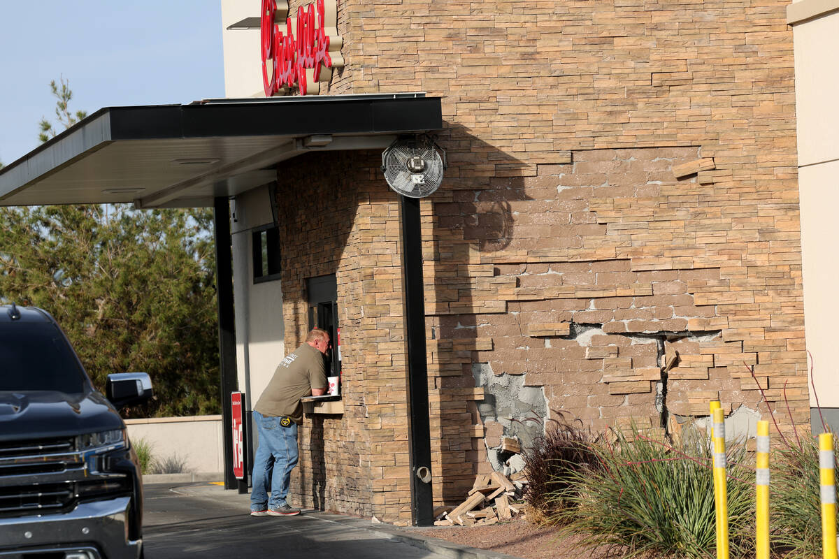 Workers make preparations to repair a Chick-fil-A after a car struck the business in Henderson ...