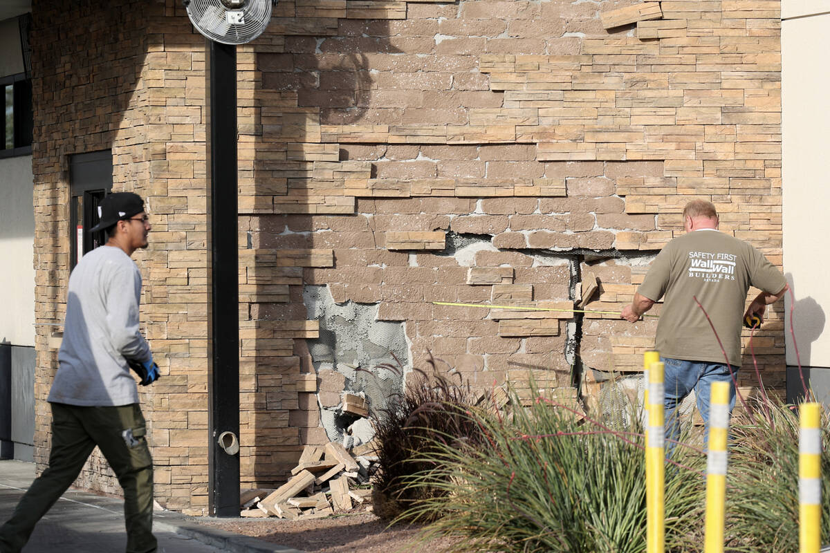 Workers make preparations to repair a Chick-fil-A after a car struck the business in Henderson ...