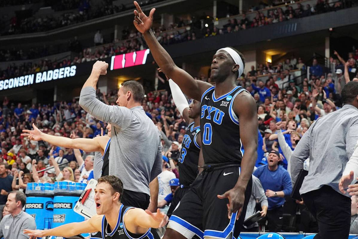 Brigham Young forward Mawot Mag and teammates react after forward Richie Saunders made a three- ...