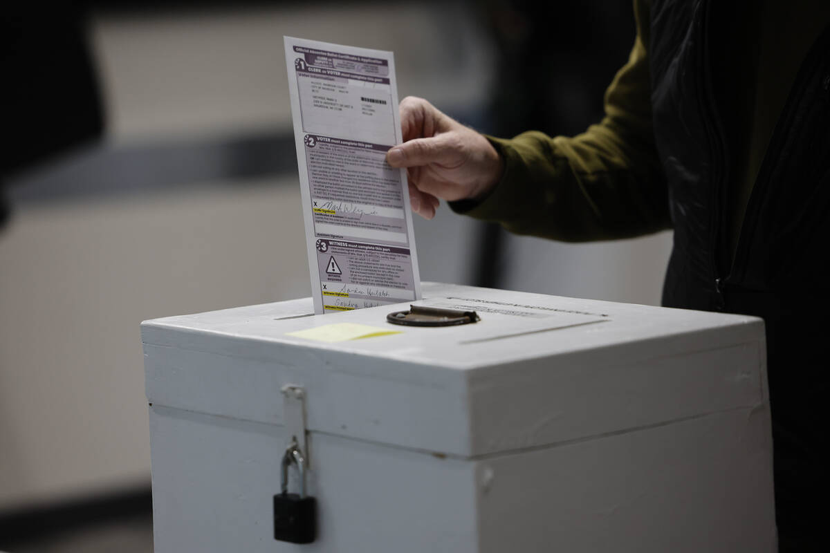 A man places his ballot in a box during early voting in Waukesha, Wis Tuesday, March 18, 2025. ...