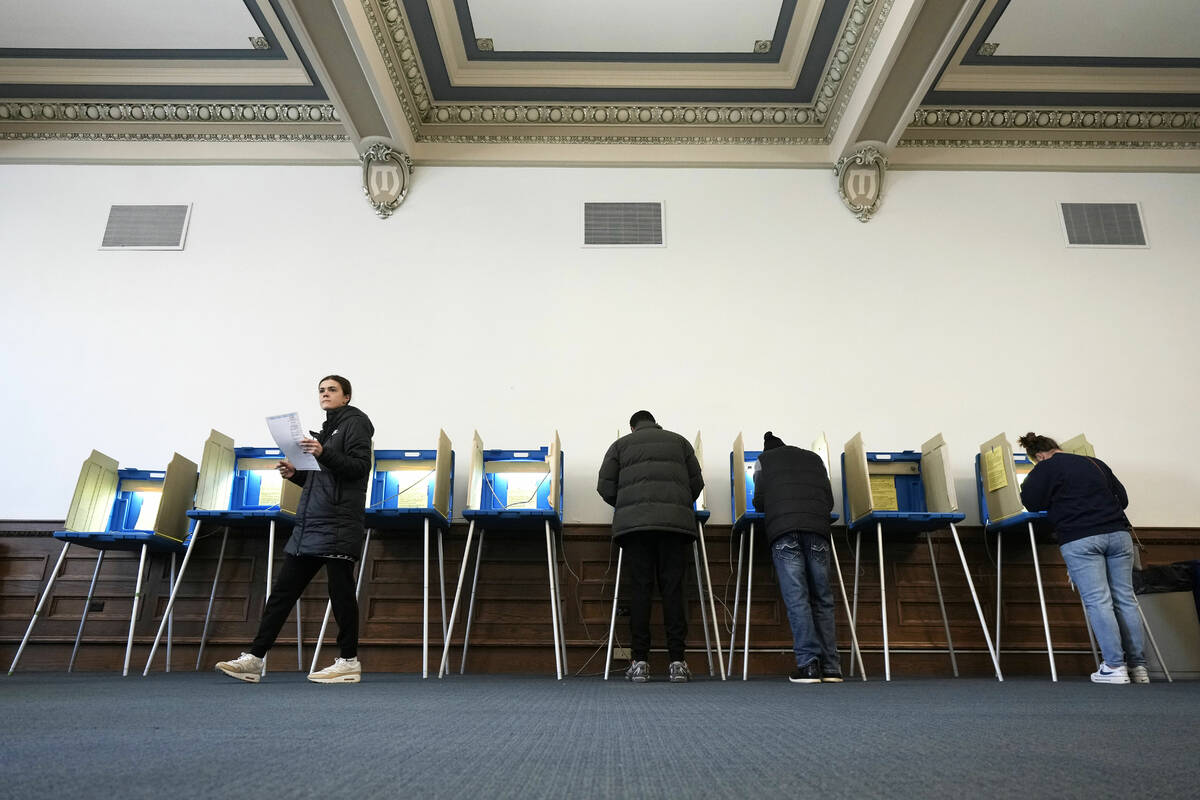 Voters mark their ballots while voting at Centennial Hall at the Milwaukee Central Library on E ...