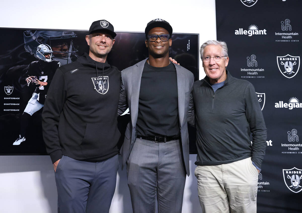 Raiders general manager John Spytek, left, Geno Smith, and head coach Pete Carroll pose for a p ...