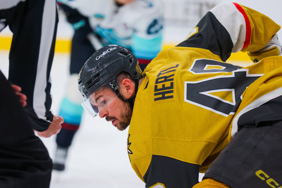 Golden Knights center Tomas Hertl (48) narrows his eye to the puck in a referees hand during a ...