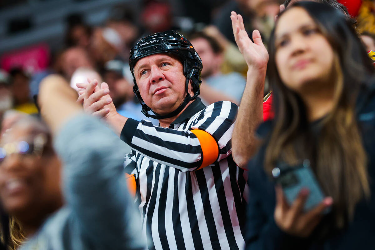 A fan dressed as a referee claps after a Golden Knights goal during an NHL hockey game between ...