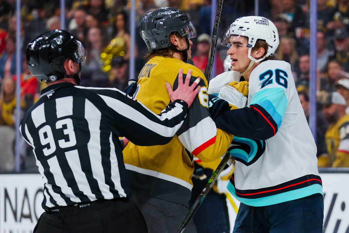 A referee splits up a fight between Golden Knights defenseman Kaedan Korczak (6) and Seattle Kr ...