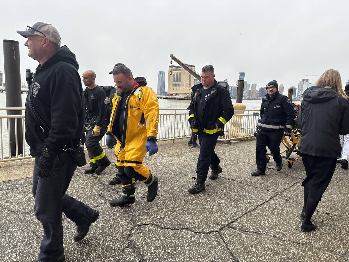 First responders walk along Pier 40, Thursday, April 10, 2025, in New York, across from where a ...