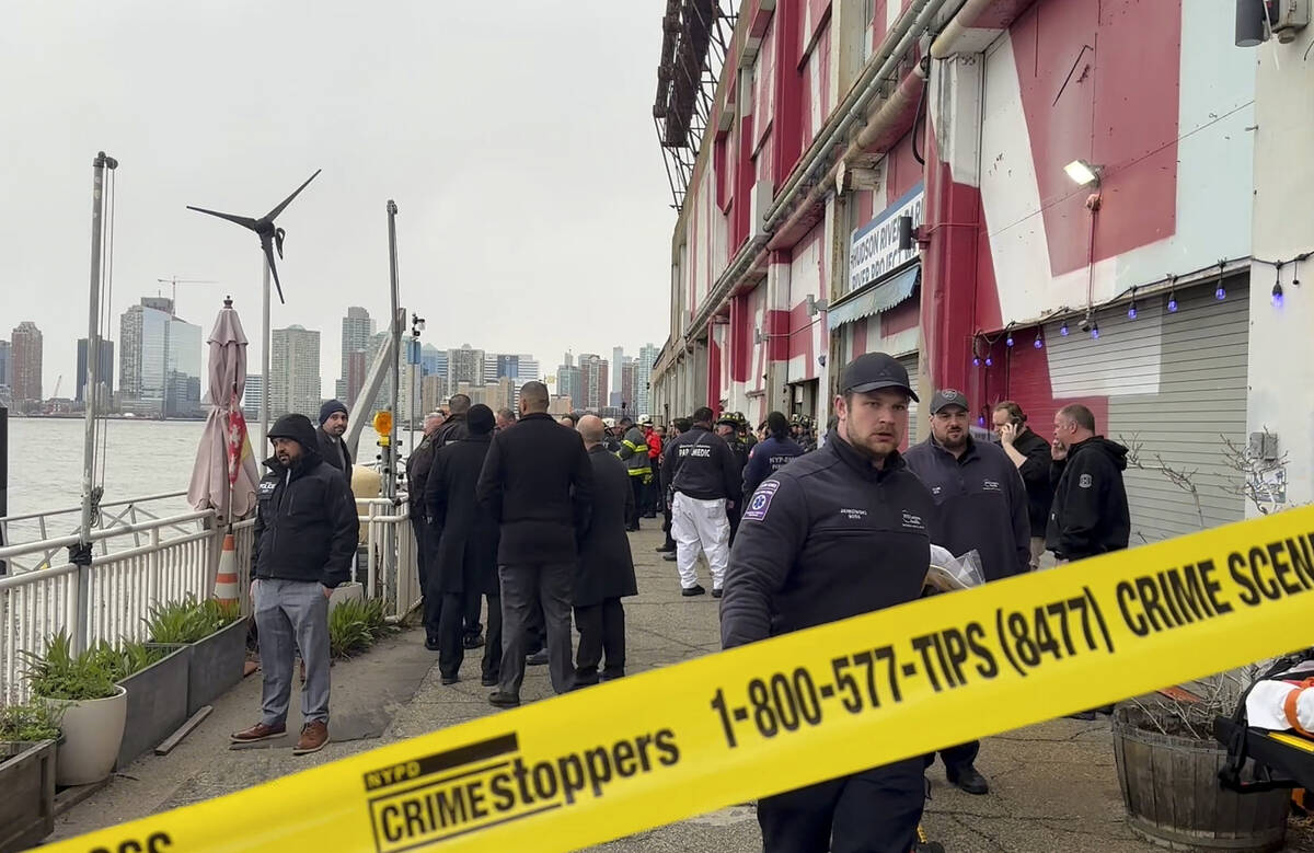 First responders walk along Pier 40, Thursday, April 10, 2025, in New York, across from where a ...