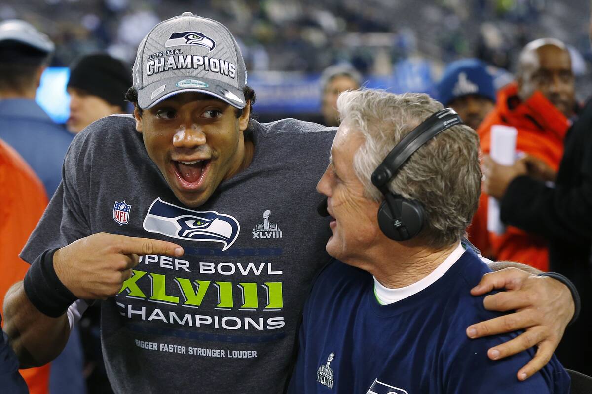 Seattle Seahawks' quarterback Russell Wilson, left, laughs with Seahawks head coach Pete Carrol ...