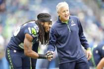Seattle Seahawks cornerback Richard Sherman, left, shakes hands with Seattle Seahawks head coac ...