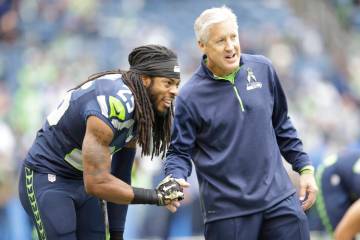 Seattle Seahawks cornerback Richard Sherman, left, shakes hands with Seattle Seahawks head coac ...