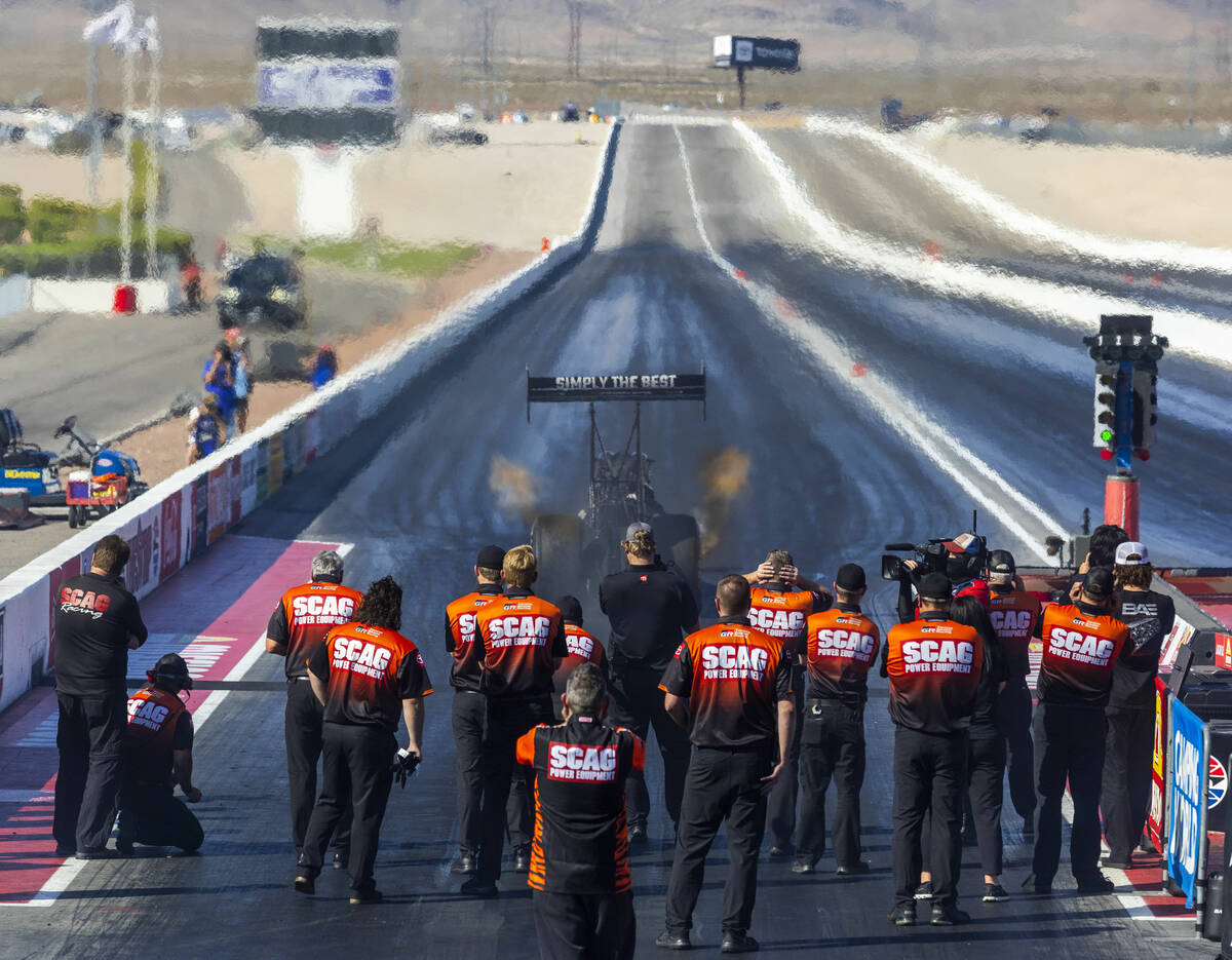 Top Fuel driver Justin Ashley leaves the start as he is team stands in support during qualifyin ...