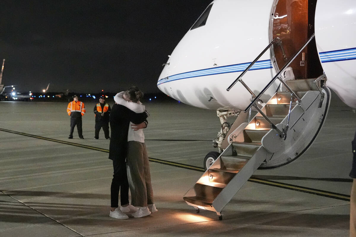 Ksenia Karelina hugs her fiancé, professional boxer Chris van Heerden, as she arrives Thur ...