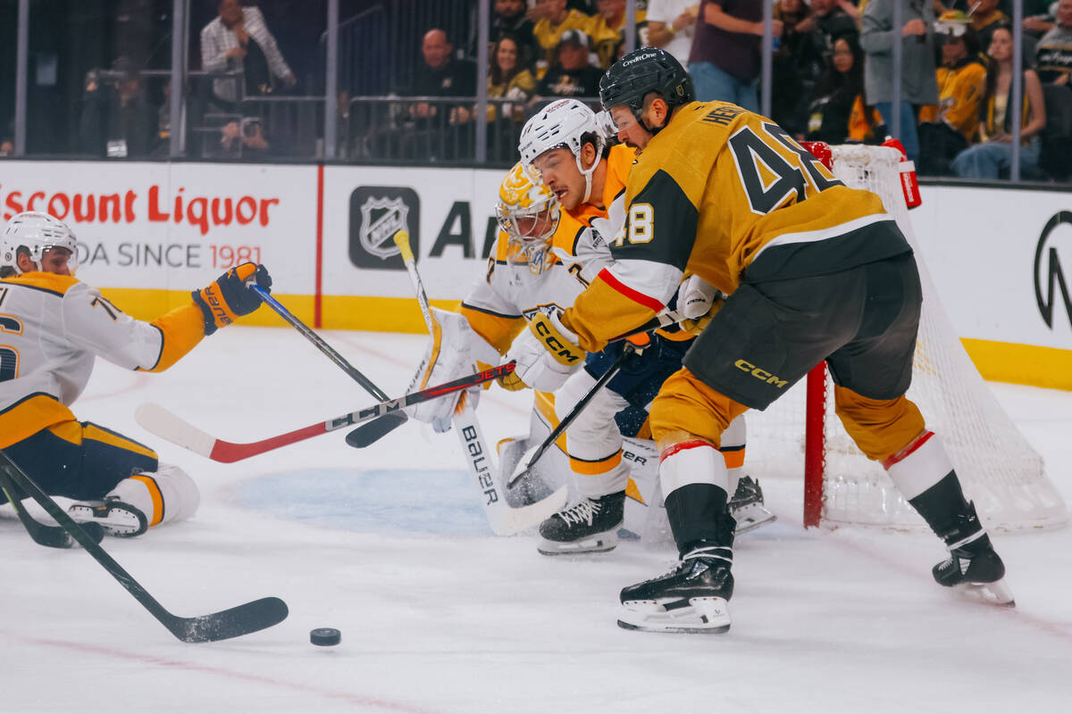 Golden Knights center Tomas Hertl (48) fights for control of the puck against multiple Predator ...