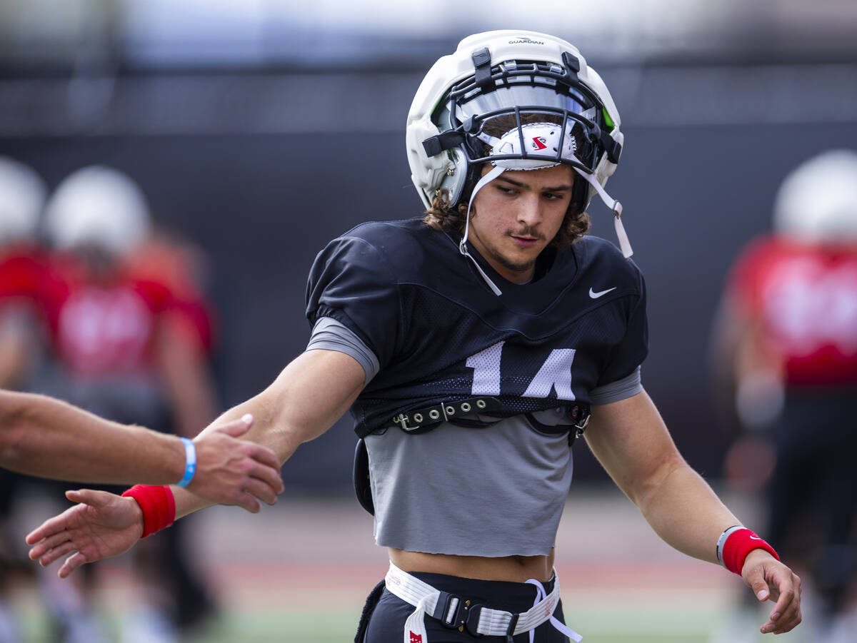 UNLV quarterback Gael Ochoa (14) gets a hand from a teammate during football spring practice a ...