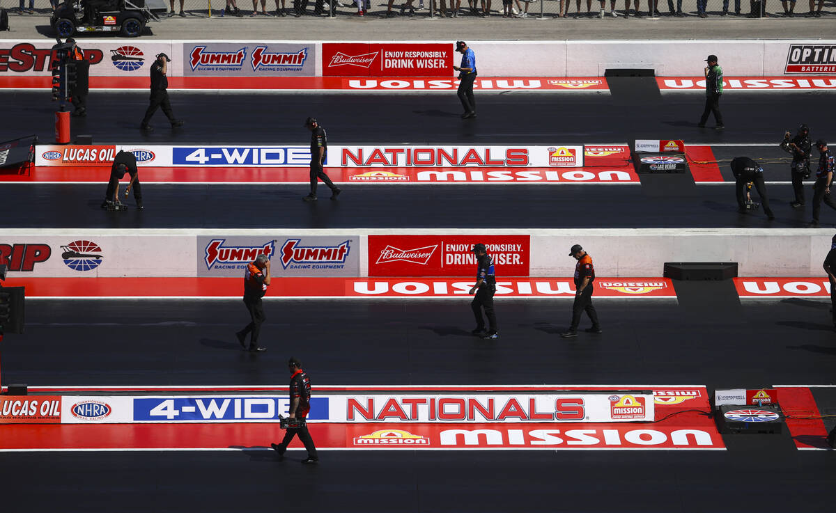 Officials and crew members check the track during the NHRA 4-Wide Nationals at The Strip at Las ...