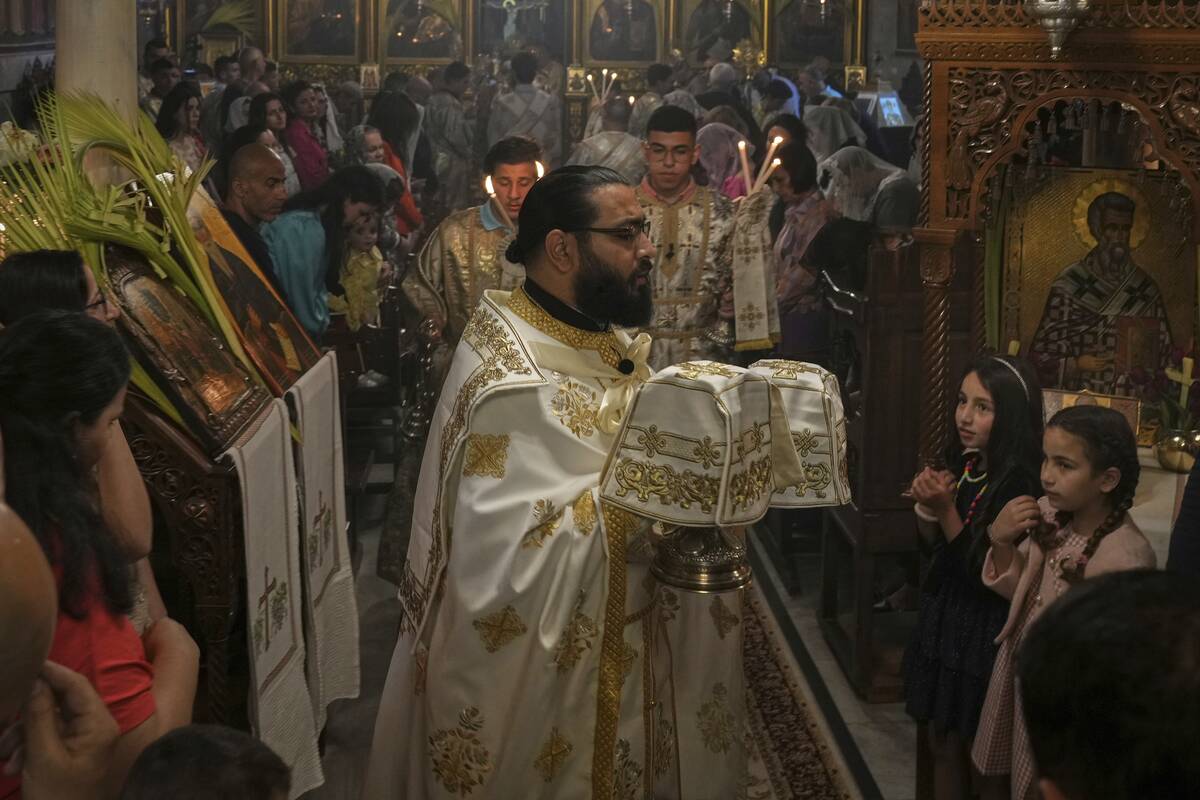 Palestinian Christians attend a Palm Sunday mass at the Greek Orthodox Church of Saint Porphyri ...