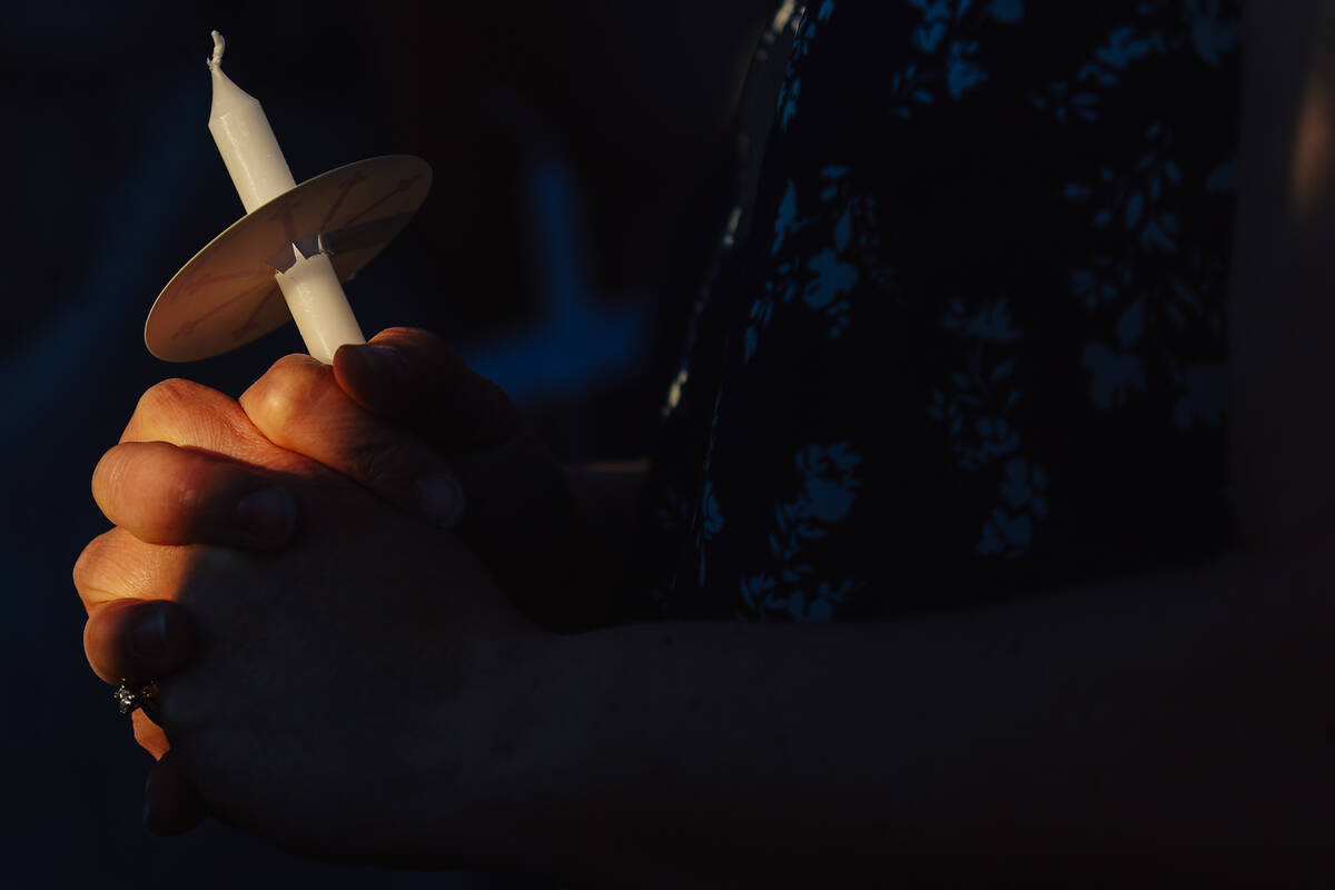 A mourner holds a candle during a vigil for Jordon Dodder, who died after a crash at the inters ...