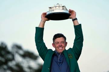Winner Rory McIlroy, of Northern Ireland, holds the trophy at the Masters golf tournament, Sund ...