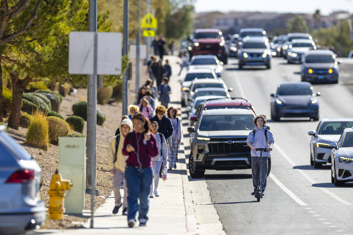 A student rides an electric scooter along Coronado Center Drive from Coronado High School on Th ...