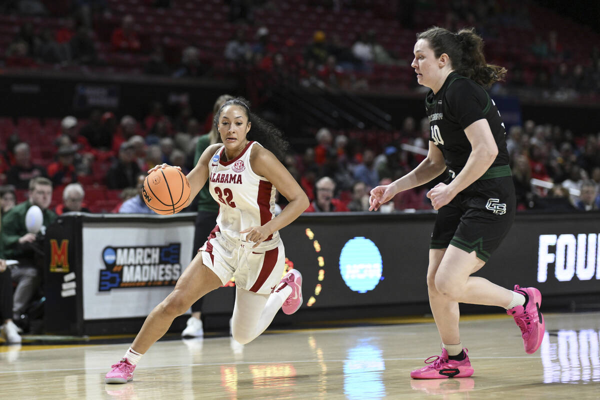 Alabama guard Aaliyah Nye (32) drives to the basket as Green Bay center Jenna Guyer defends dur ...