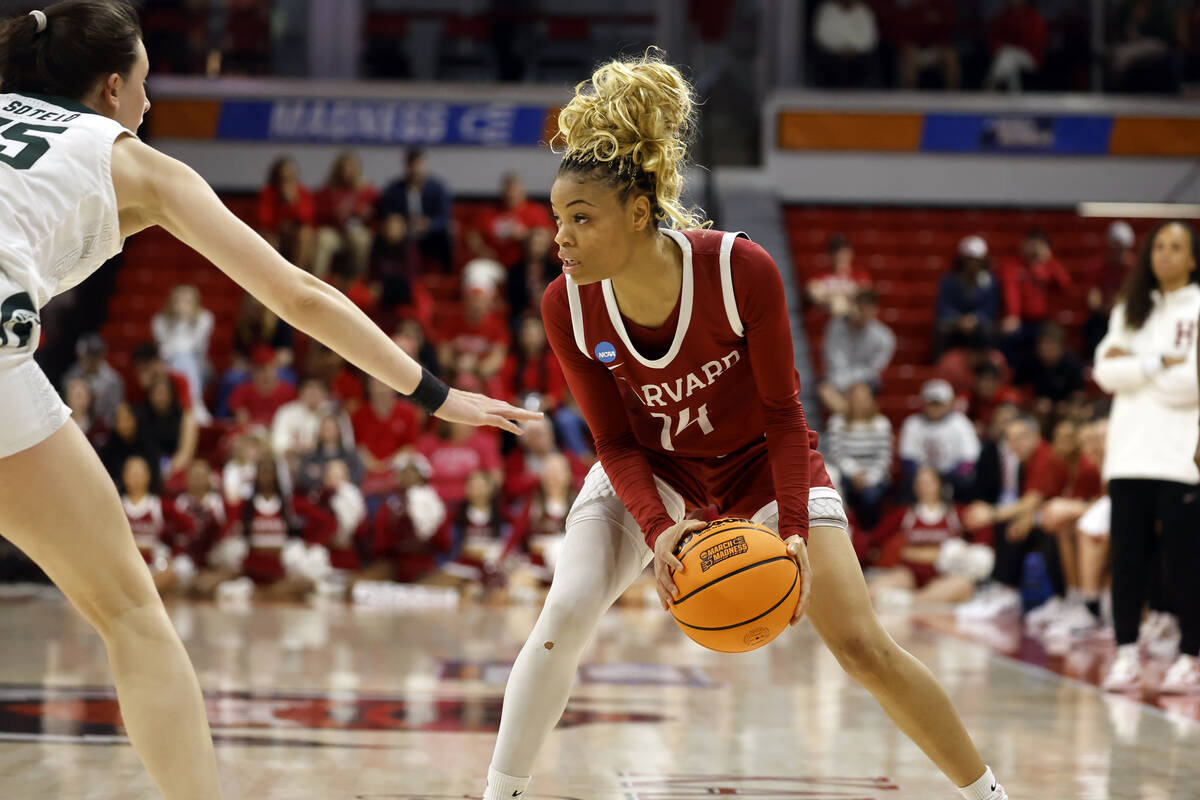 Harvard's Harmoni Turner (14) looks to move the ball around Michigan State's Ines Sotelo (15) d ...