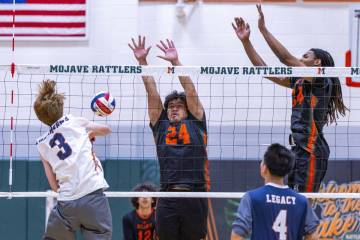 Legacy's Isaac Schultz (3) spikes a ball past Mojave's Mailetoa Siu (24) and Quintrell McGee (3 ...