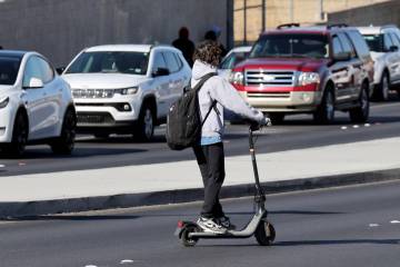 A student rides an electric scooter on Coronado Center Drive outside Coronado High School in He ...