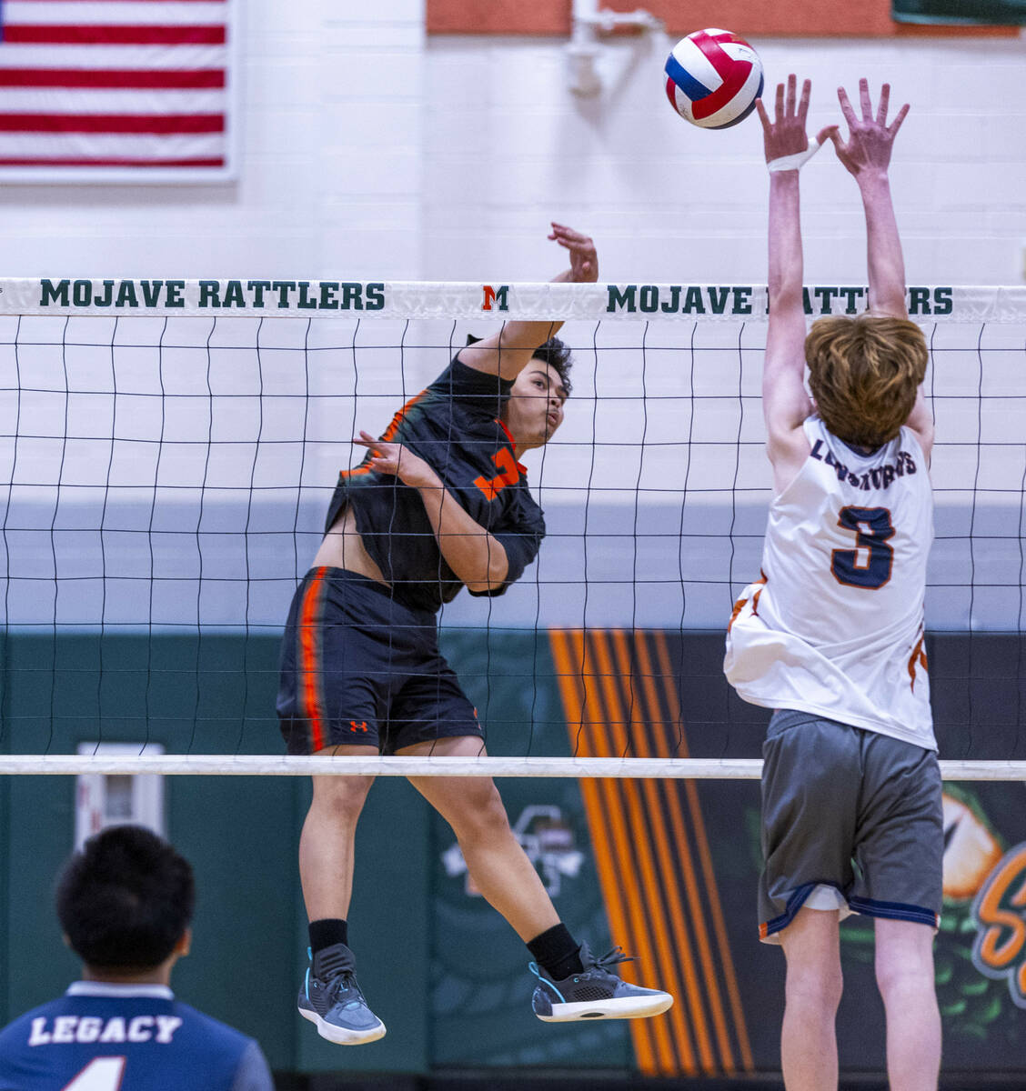 Mojave's Jhoemel Bagalawis (7) spikes the ball against Legacy's Isaac Schultz (3) during their ...