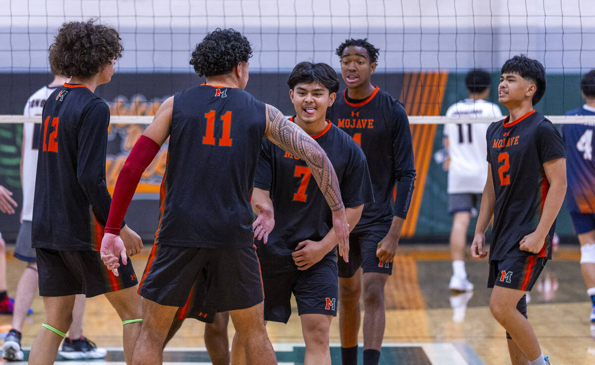 Mojave players celebrate a game win against Legacy during their 4A boys volleyball game on Tues ...