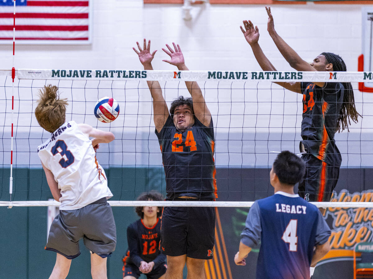 Legacy's Isaac Schultz (3) spikes a ball past Mojave's Mailetoa Siu (24) and Quintrell McGee (3 ...
