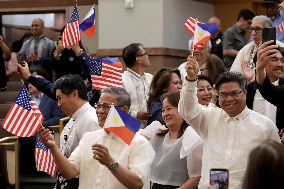 Audience members wave Filipino and American flags during a Clark County Commission meeting wher ...
